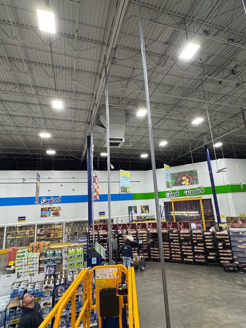 A retail sales floor with ceiling lighting and a lift positioned in the aisle